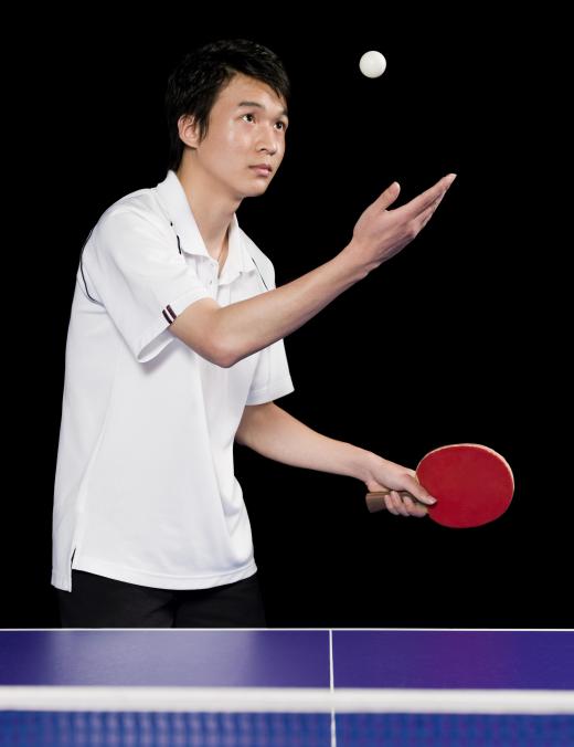 Table tennis player serving the ball.