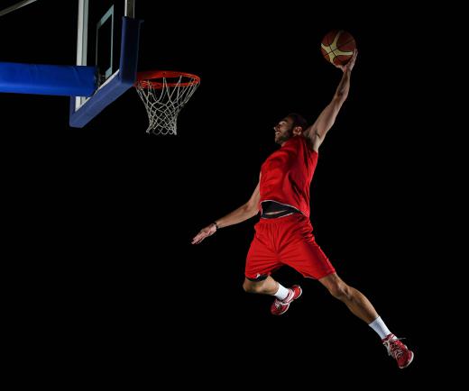 Basketball players use an ally oop pass to set up a slam dunk.