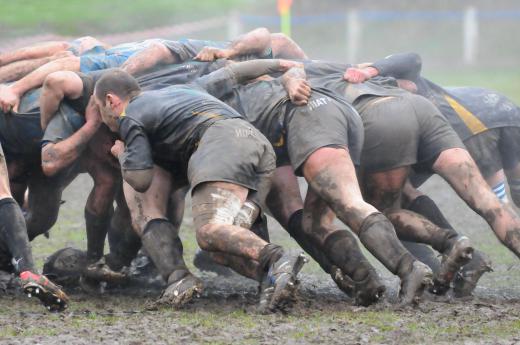 Muddy rugby scrum.